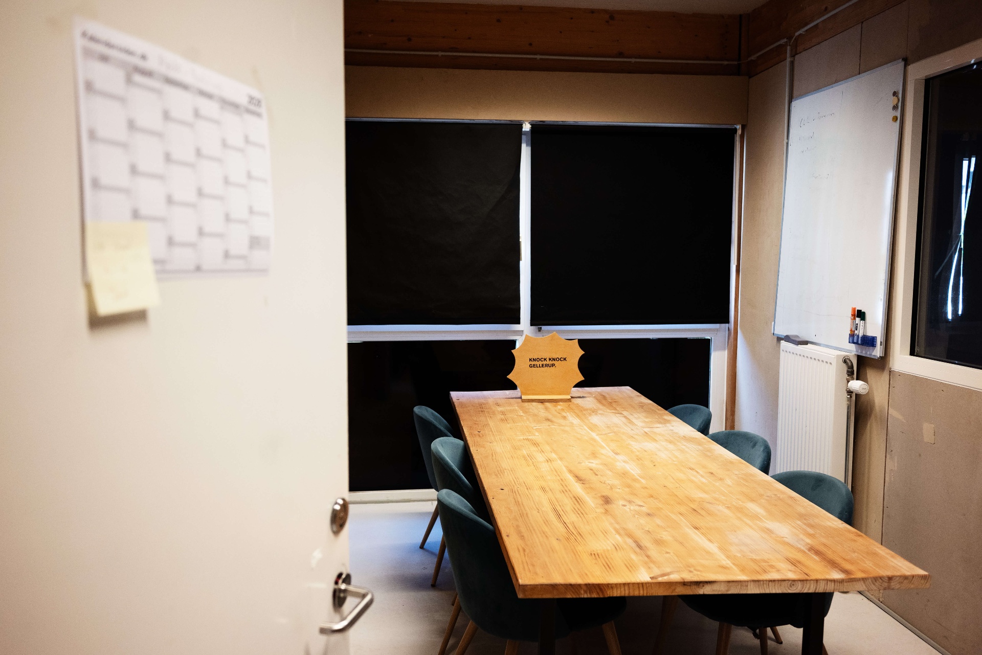 Mødelokalet på Square One med massivt træbord, lænestole og whiteboard